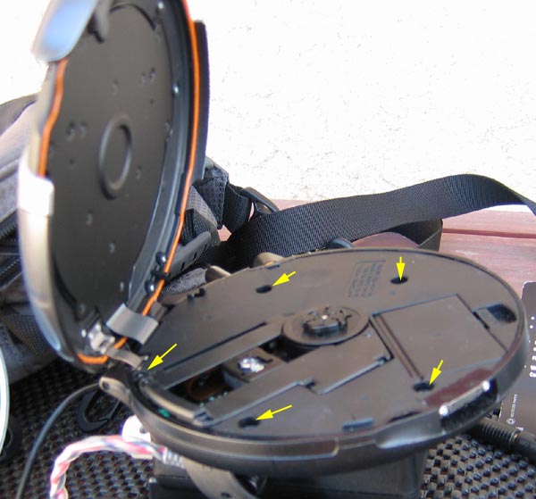 Start by lifting the hinged cover and, then, unscrewing the chassis cover (note the arrows -- there are five screws).